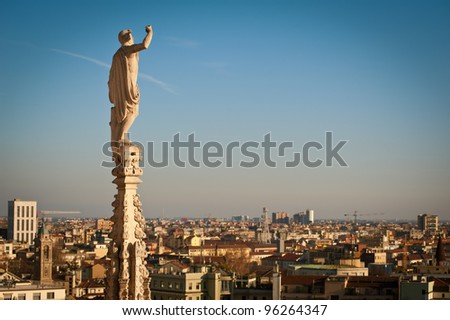 Gothic spire on the roof of Milan Dome with city landscape as background. Milan, Italy.