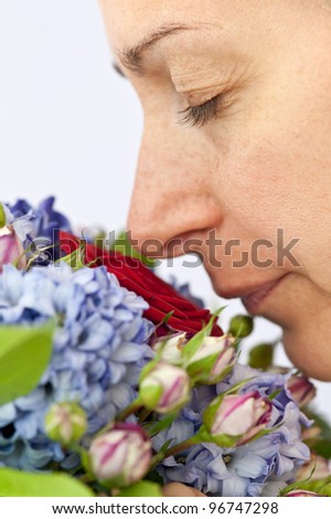 Portrait of pretty woman smelling a flower's bouquet.