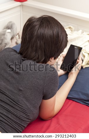 teenager with smart phone on the bed