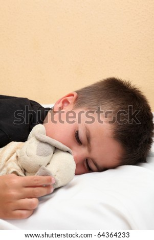 Cute sleeping child cuddling teddy bear