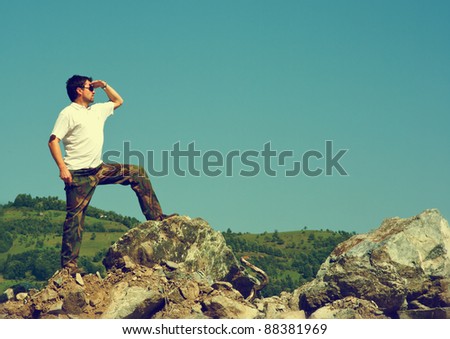 Retro image of a man standing on stones and looking ahead