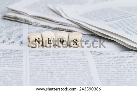 News formed by wooden letters, on top of newspapers