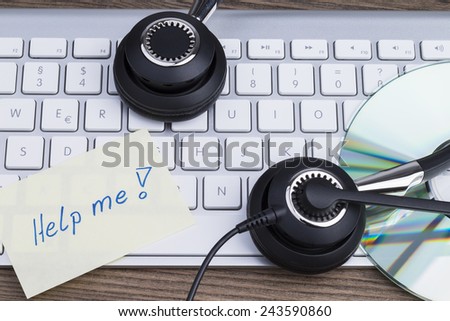 Image shows a computer keyboard, a disc, a memory stick and a headset with sticker \