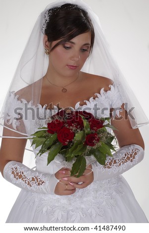 Sad bride looking on her bouquet of roses