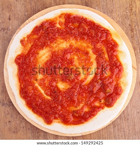 pizza base with tomato sauce