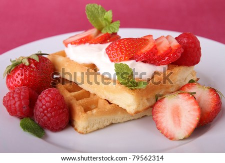 plate of waffle with whipped cream and fruit