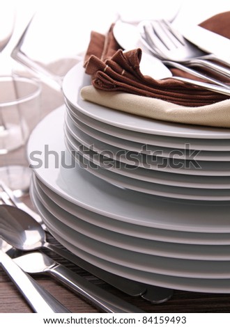 plates stack with cutlery and glasses