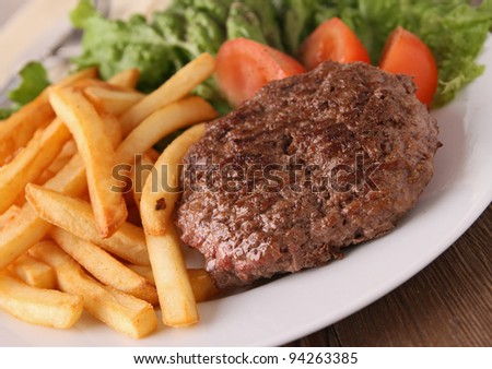 plate of steak, french fries and salad