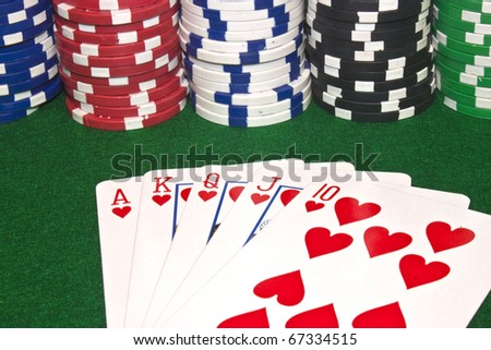 a winning poker hand of a royal flush with stacks of poker chips
