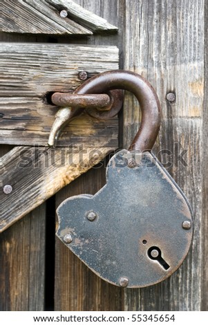 Old unlocked padlock on the wooden door