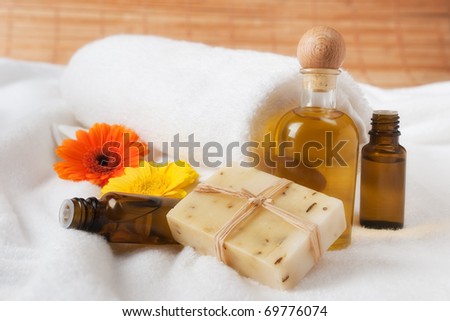 Bottle of Flower Essence, Oil and Raw Soap on Soft Towel