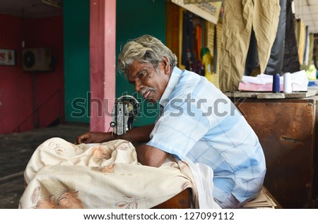 BERUWALA, SRI LANKA - NOVEMBER 13: man sewing in a small tailor shop, industrial sewing machine on November 13, 2012 in Beruwala, Sri Lanka. Sri Lankan private sewing industry.