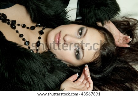 beautiful young woman in black fur with black necklace