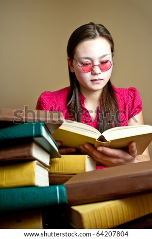 stock photo Girl wearing pink round glasses reading book