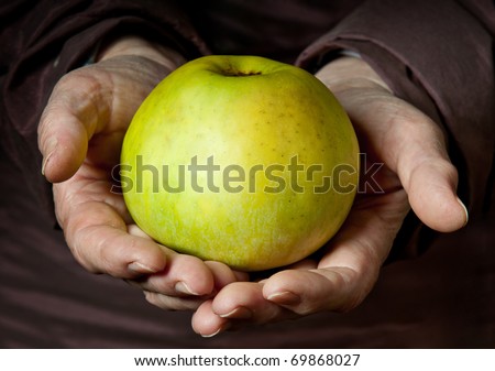 Senior Woman Holding Apple in her Palms.