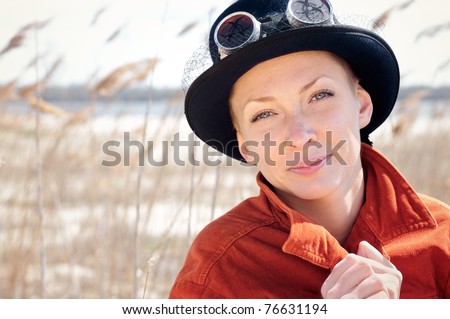 woman wearing vintage hat and danger-style glasses  in reed