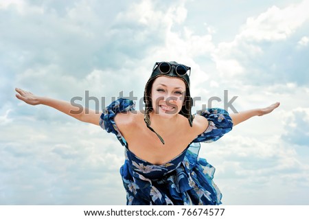 Young woman wearing aviator hat flying up