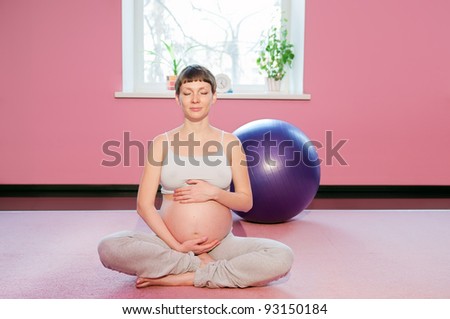 Young pregnant woman doing pregnancy yoga