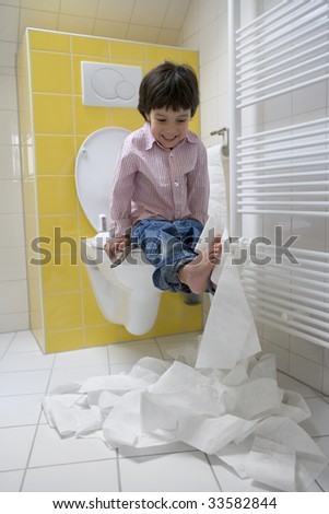 Naugthy little boy making a mess with toilet-paper