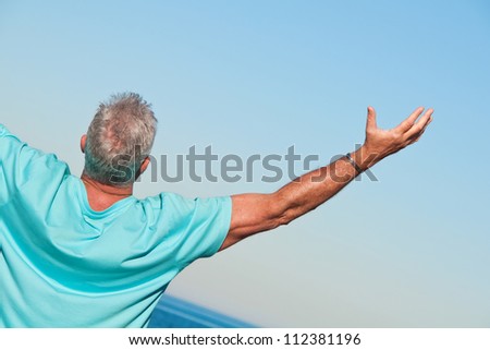 Man on the beach praising - stock photo