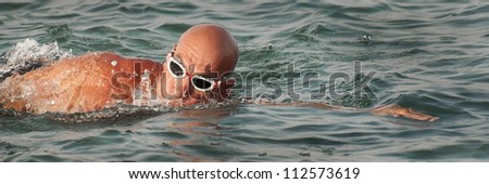 Fit mature man swimming in the sea with goggles