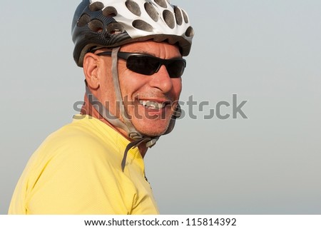 Portrait of a senior man smiling wearing a cycling helmet