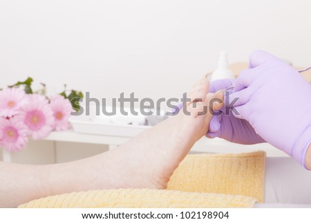 podiatrist ( chiropodist ) at work,cleaning womans feet.