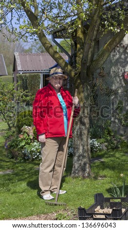 Portrait of a retired woman working in the garden and doing spring garden work.