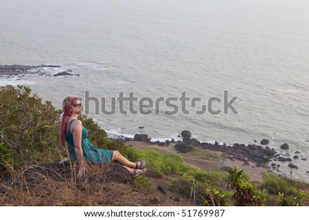 woman relaxing and watching the sunset in Goa,India. location: Anjuna Beach
