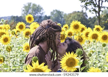 Young couple in love kissing in sunflower field