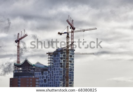 construction site with 2 cranes and a dramatic sky. location: Hamburg, Germany.