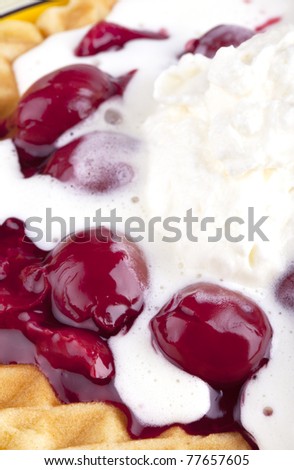 studio-shot of a plate with a hot waffle topped with hot cherries and whipped cream concept image: sweet snack.