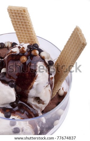 studio-shot of a ice cream bowl with stracciatella, walnut and vanilla ice cream topped with chocolate balls and nougat syrup, isolated on white
