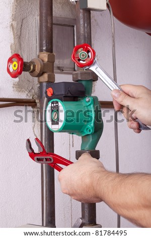 studio-shot of a heating engineer repairing and maintaining the heating system of a single-family house.