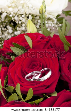stock photo studioshot of white gold wedding rings on a bridal bouquet 
