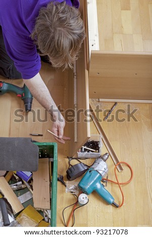 studio-shot of a carpenter using a wooden folding rule to check measurements. carpenter is building a bed