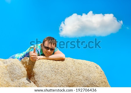 Happy young man lies on the edge of a cliff. Series Emotions / Feelings   #04 photos