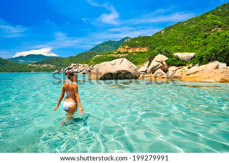 Young beautiful woman resting on the sunny  tropical lagoon in white bikini. Summer holidays concept