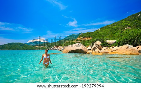 Young beautiful woman resting on the sunny  tropical lagoon in white bikini. Summer holidays concept