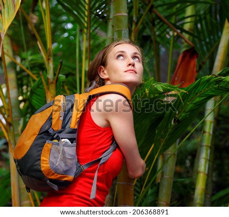 Young tourist with backpack walking in tropical forest.Travel to Asia, happiness emotion, summer holiday concept