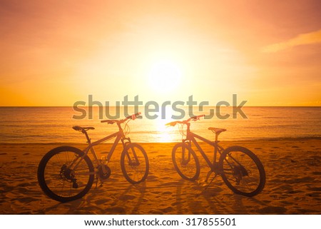 Two bike silhouette at the beatiful sunset near sea. Travel background