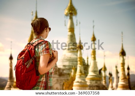 Backpacker traveling  with backpack and looks at Buddhist stupas. Myanmar