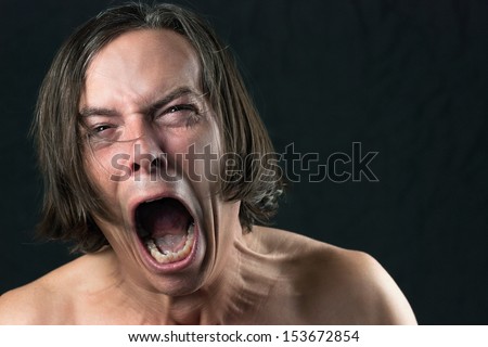 Close-up of a man screaming in agony.