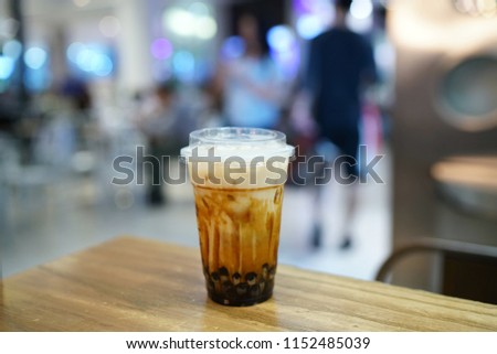 Bubble Milk Tea - A glass of fresh milk with black sugar syrup and black pearl (Boba) on blurred background, Taiwanese style.