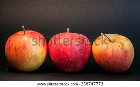 Three apples on black background