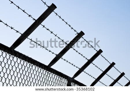 Silhouette of a Barbed Wire Fence against clear Sky