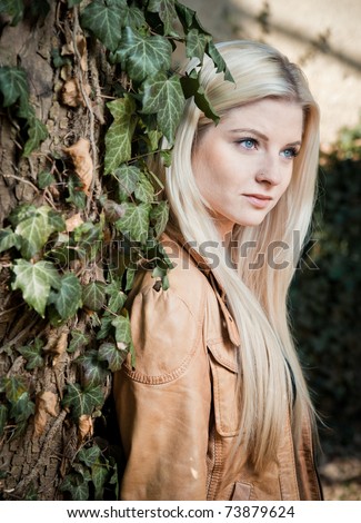 Blonde leaning on Tree full with Ivy