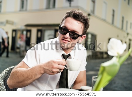 Cool young man drinking coffee in the city