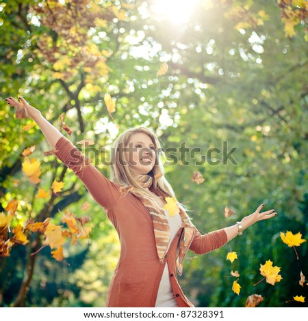 Blonde woman and falling leaves in autumn
