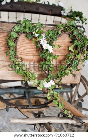 Heart-shaped wreath on a wooden wedding carriage